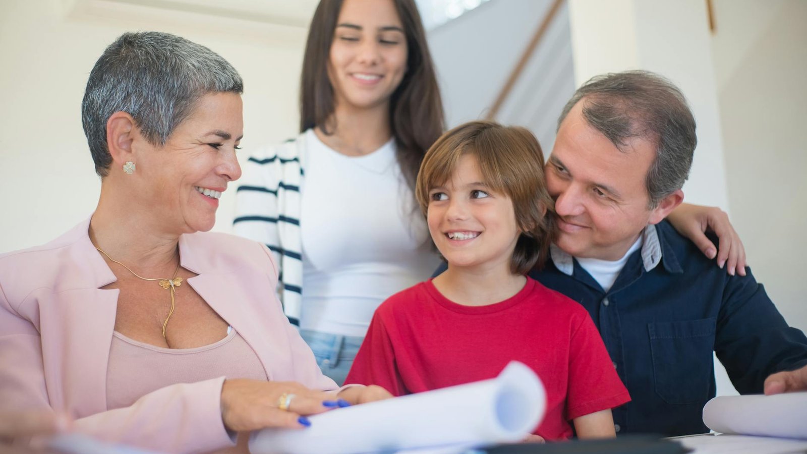 A multigenerational family gathered warmly around documents in a domestic setting